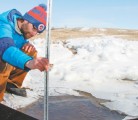 Henry Wilson, an Agriculture Canada hydrologist and biogeochemist in Brandon, measures the water depth of runoff at a field near Sioux Valley, Man. Wilson is collecting water samples from 10 annually cropped fields in southwestern Manitoba this spring as part of a research project to understand the interaction between land management, landforms, soil nutrients, climate and the amount of nutrients that flow off the field. | Robert Arnason photo