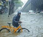 A man in Mumbai, India, pushes his bicycle through a flooded road during monsoon rains. Rain accumulations in this monsoon season are much higher than normal and could be harming crops in some regions while helping them in others. | reuters photo