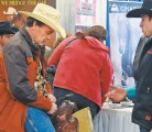 David Esmond of Eyebrow, Sask., takes a test ride on a display saddle from DK Saddlery, shown by Cory McAllister of Calgary during the Equine Expo trade show, held in Saskatoon Feb. 14-16. | William DeKay photo