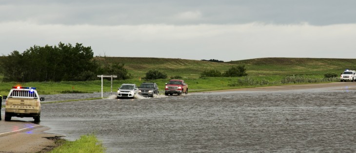 RCMP direct traffic on Highway 16, 1 Km. east of Elfros, Sask., after flash flooding covered the highway June 30, 2014. | Robin Booker photo