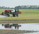 While flood waters continue to pour onto his land, Cortney Solonenko of Tonkin, Sask., finds the high ground to spray for weeds on his canola fields July 3. Producers were facing a compressed spraying season before recent rains, but experts suggest keeping a lid on speed where possible. | William Dekay photo